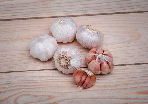 Close garlic on wooden texture on for cooking on black background