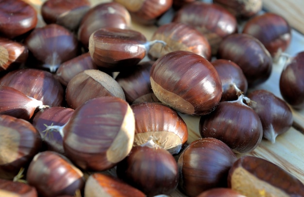 Chiudere su un gruppo di castagne fresche dolci su una tavola