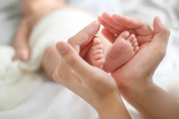 Foto stretta di mano che tiene i piedi del neonato