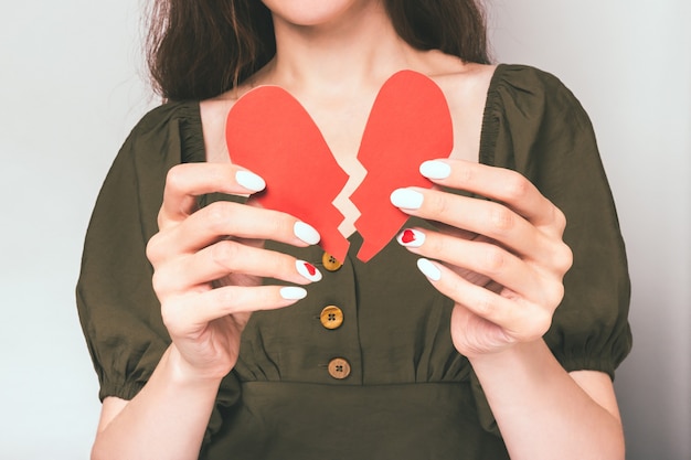 Close portrait of a girl in love holding a paper heart