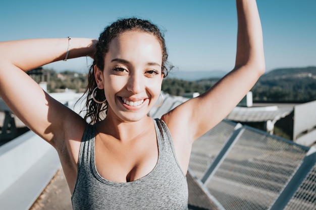 Close portrait of a smiling young african arab poc happy after\
finishing her training. new habits fit life new year concept.\
colorful, losing weight gaining health concept