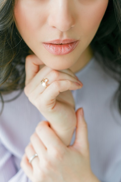 Close portrait of a young beautiful curly woman in a lilac dress