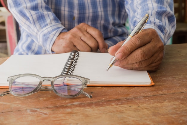 Close shot of a human hand writing something on the paper