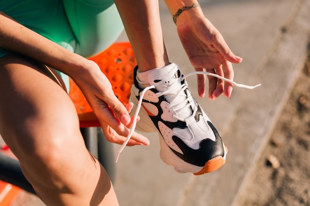 Photo close shot of woman tied the laces on the sneakers sunset light