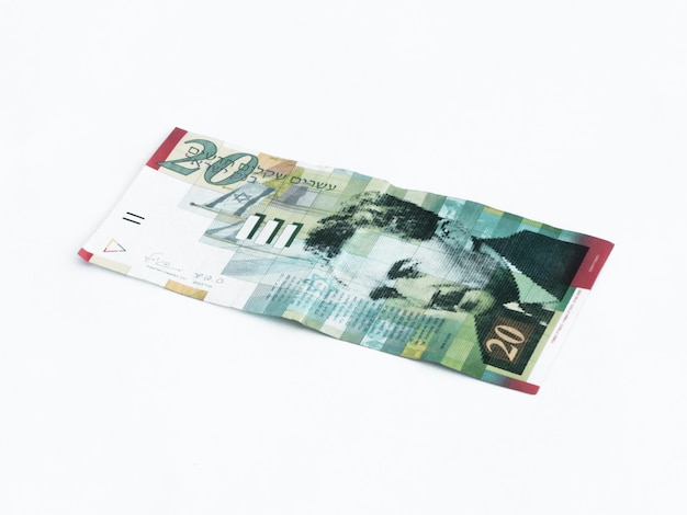 Foto close-up di una banconota di 20 shekel israeliani su sfondo bianco
