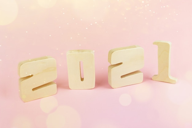 Close-Up 2021 wooden calendar on pink table background with copy space for text. New Year 