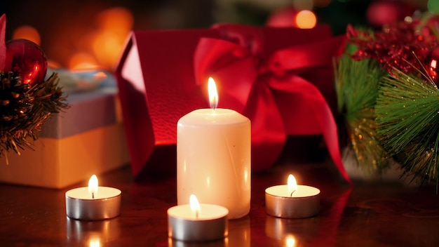 Close-up 4k-beelden van brandende adventskaarsen tegen kerstcadeaus en cadeautjes in de woonkamer met brandende vuurplaats. Perfecte achtergrond of achtergrond voor Kerstmis of Nieuwjaar