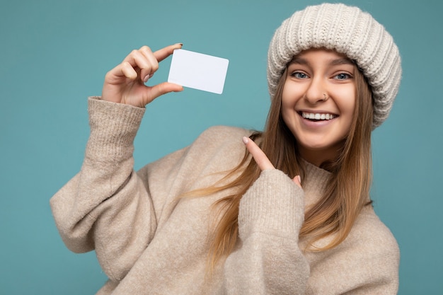 Close-up aantrekkelijke sexy positieve glimlachende jonge donkere blonde vrouw die beige sweater draagt en