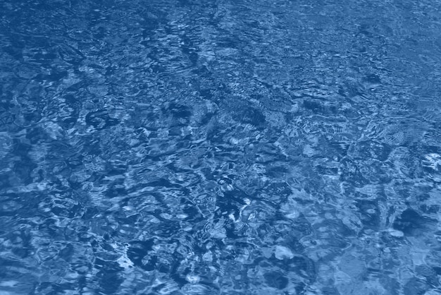 Close up abstract water texture. swimming pool water in monochrome color background. trendy blue and calm color. copy space, top view