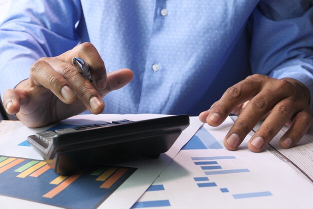 close up of accountant using calculator on office desk.