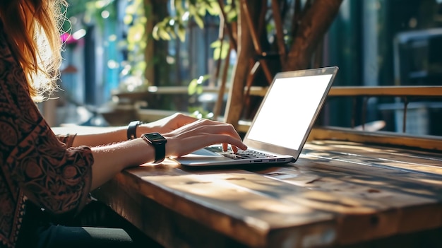 Foto close-up achteruitzicht van een jonge zakenvrouw die aan een generieke laptop werkt aan een bureau met een mobiele telefoon