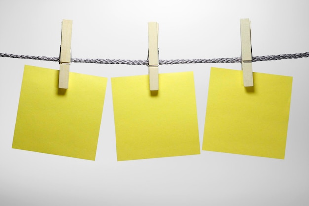 Photo close-up of adhesive notes on rope against white background