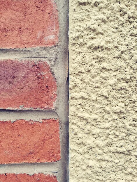 Photo close up of adjacent external walls red brick and stucco