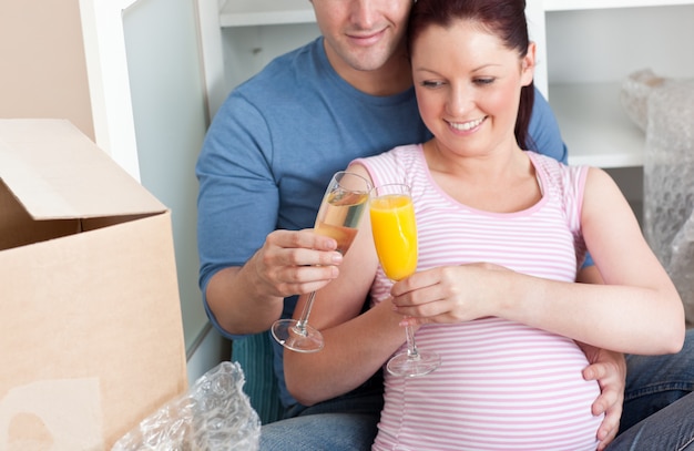 Chiuda in su di una coppia adorabile che celebra la gravidanza e la rimozione con champagne