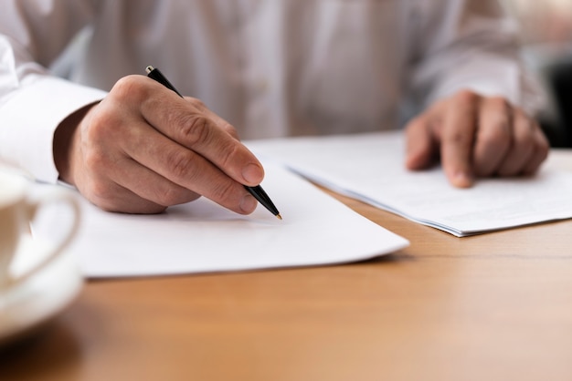 Photo close-up adult signing a contract at the office