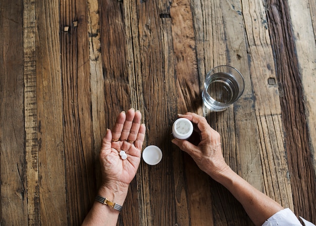 Close up of an adult taking medication 