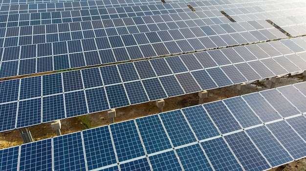 Close up aerial view over Solar Panels Farm (solar cell) with sunlight.