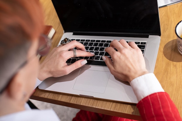 Close-up afbeelding van vrouwelijke handen die op het toetsenbord van een laptop typen