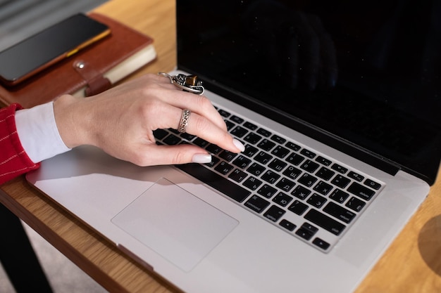 Close-up afbeelding van vrouwelijke handen die op het toetsenbord van een laptop typen