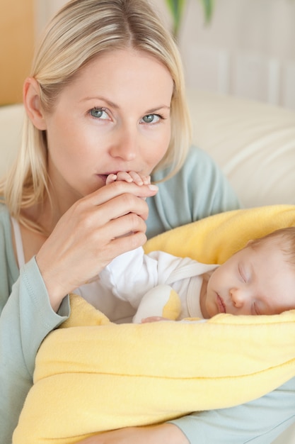 Close up of affectionate mother kissing her baby's hand