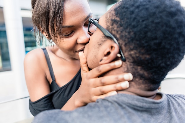 Primo piano delle giovani coppie afroamericane che baciano all'aperto di estate