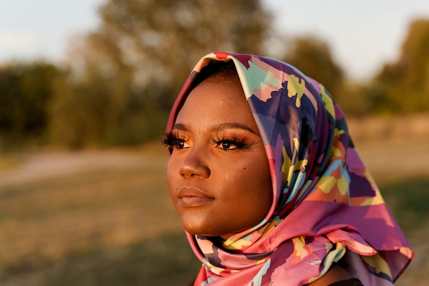 Close up african black woman weared in scarf named hijab
looking left side