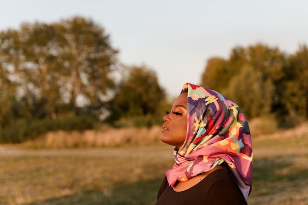 Close up african black woman weared in scarf named hijab\
looking left side