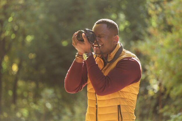 Close-up Afro-Amerikaanse man fotograaf die foto's maakt met fotocamera op stad groen park vrijetijdsbesteding diversiteit en hobby concept