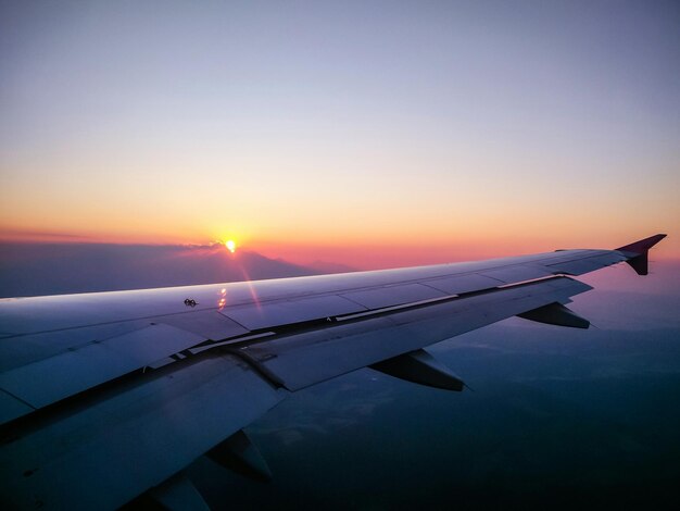 夕暮れの空に照らされた飛行機の翼のクローズアップ