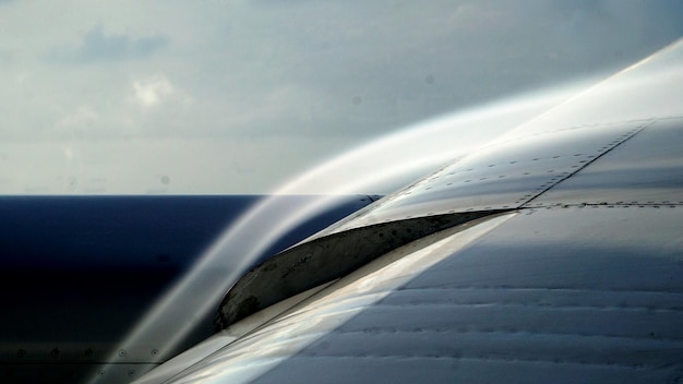 Photo close-up of airplane wing against sky