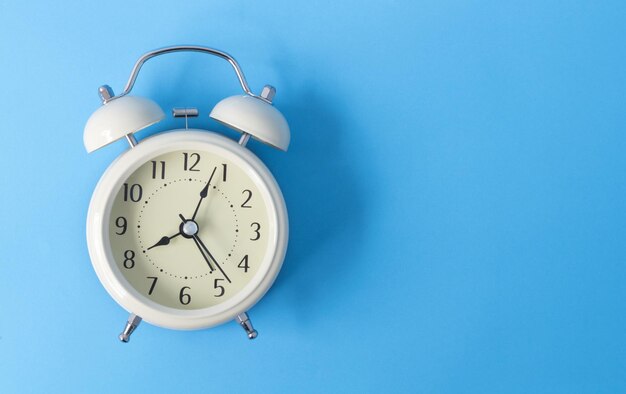 Close-up of alarm clock against blue background