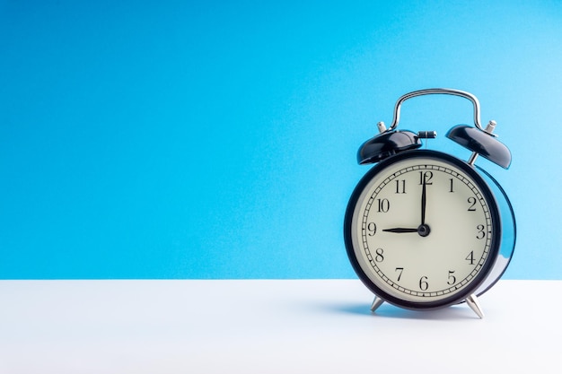 Close-up of alarm clock on blue background