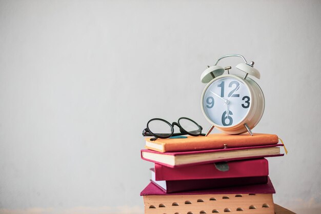 Photo close-up of alarm clock on books at home