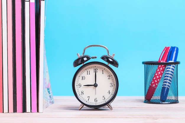 close-up of alarm clock by books on table