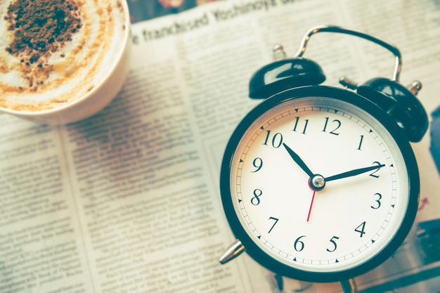 Photo close-up of alarm clock on newspaper