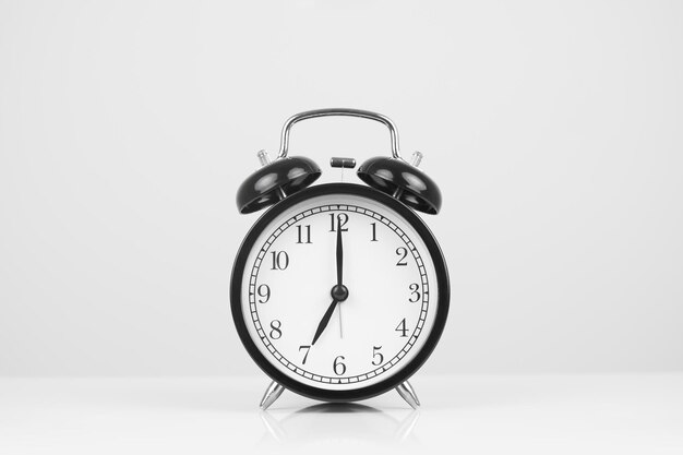 Photo close-up of alarm clock over white background