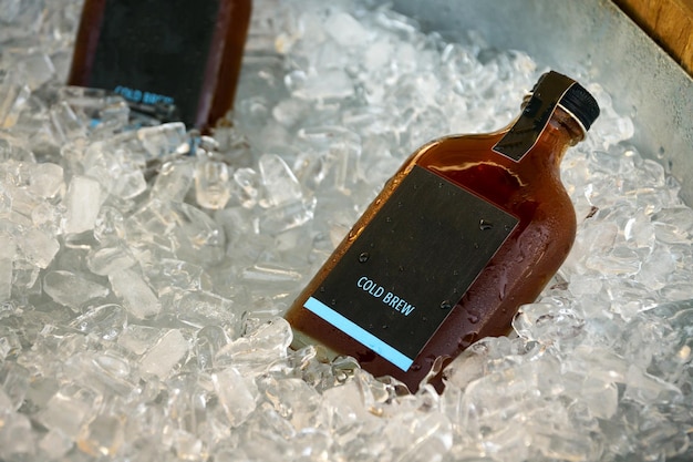 Photo close-up of alcohol bottle on ice cubes