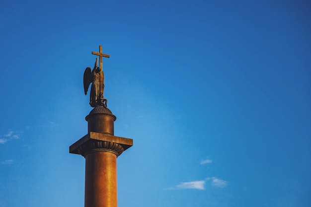 Close up of Alexander column top on Palace square background of blue sky. Unique urban landscape center St Petersburg. Central historical sights city. Tourist places in Russia. Capital Russian Empire