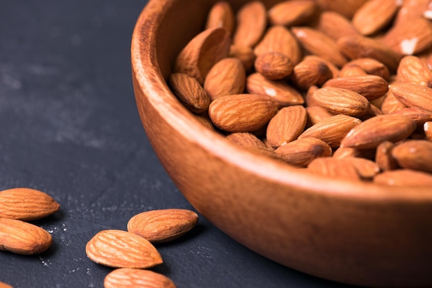 Close up. almonds in a wooden bowl on a dark background