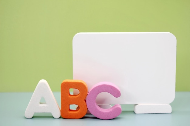 Close-up of alphabets and blank placard on table