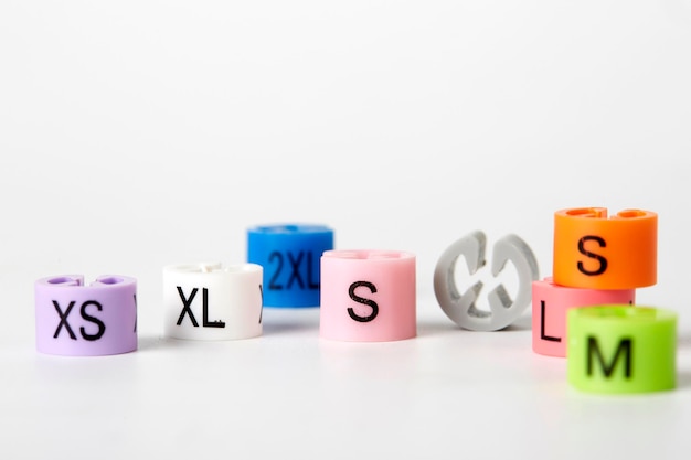 Photo close-up of alphabets on multi colored beads over white background