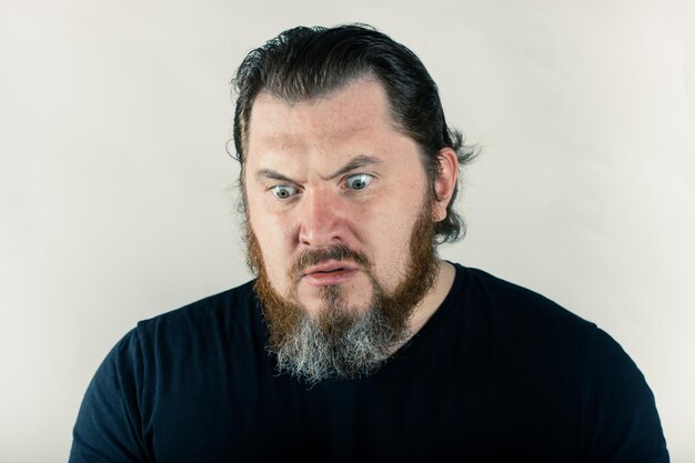 Photo close-up of angry man making face against white background