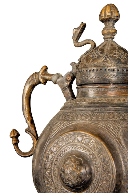 A close up of an antique metal teapot with artistic chasing and engraving on a white background