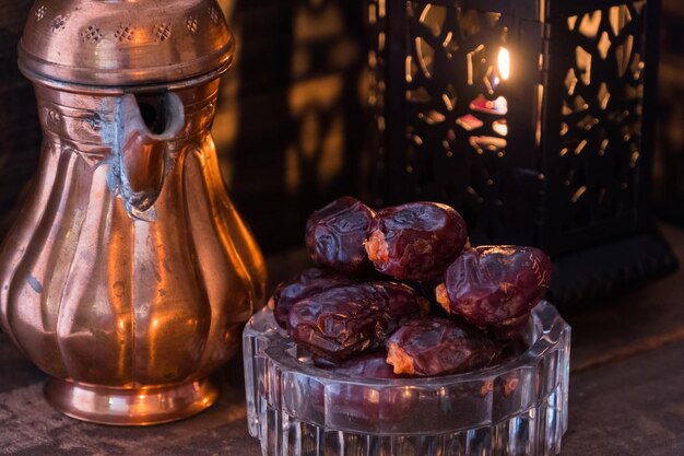 Photo close-up of antique teapot and lantern with raisins on table