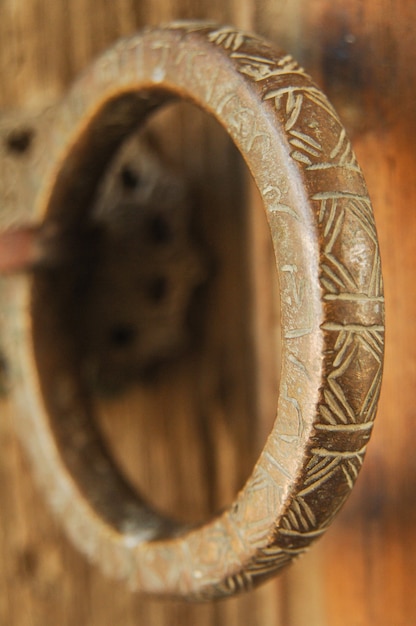 Close-up antique vintage brass ring with an engraving on the door. blurred background