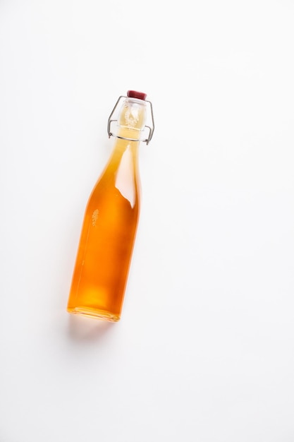 close-up of apple cider vinegar in bottle against white background