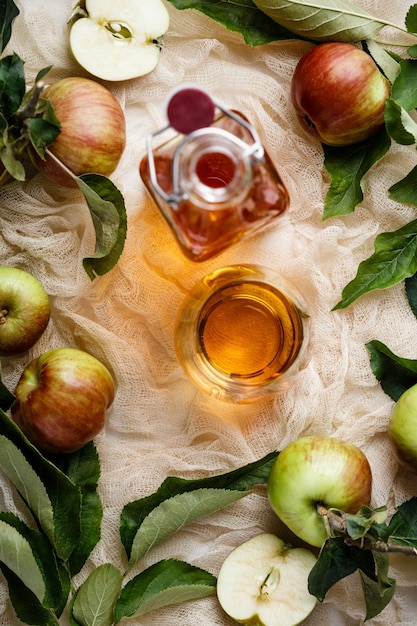 Photo close-up of apple cider vinegar in bottle on textile