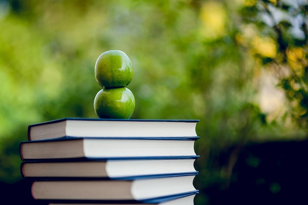 Photo close-up of apple on stack of books on table