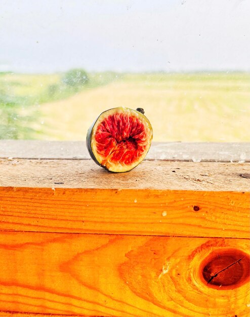 Close-up of apple on table against sea