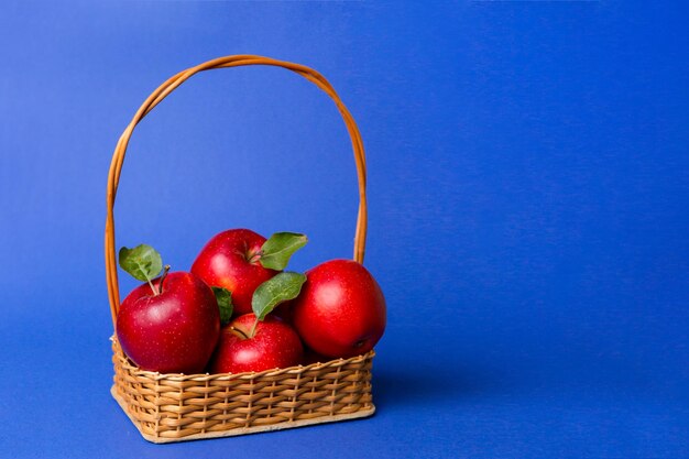 Close-up of apples in basket against blue background